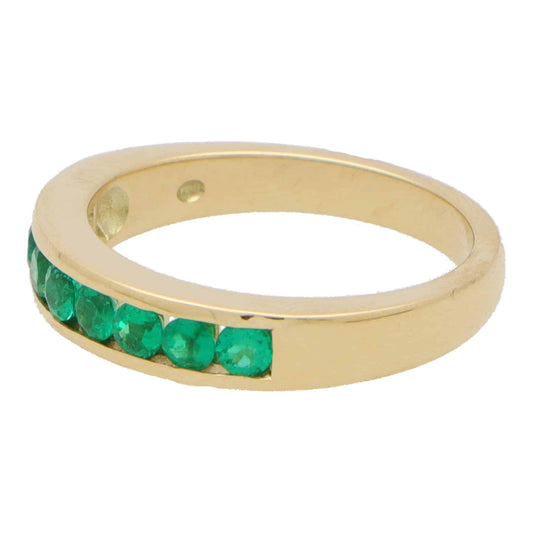 Emerald half eternity ring set in yellow gold.