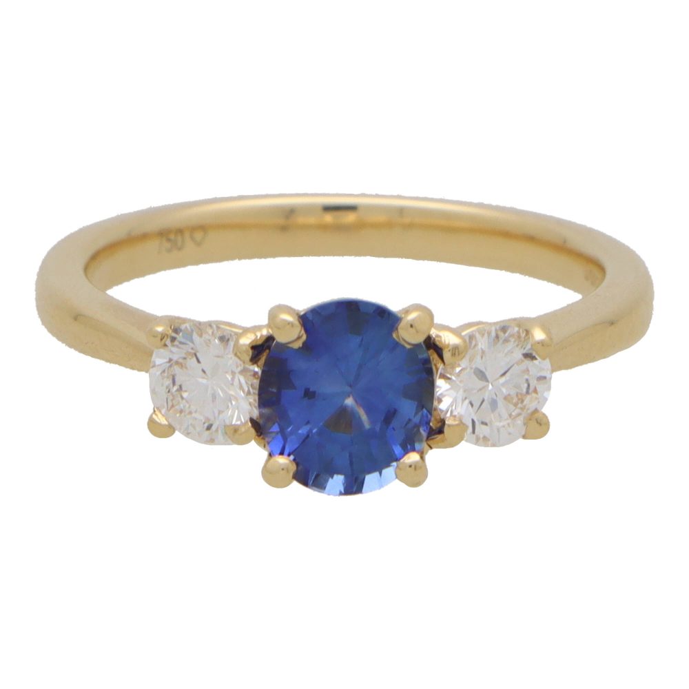 Diamond and sapphire three stone ring in yellow gold.