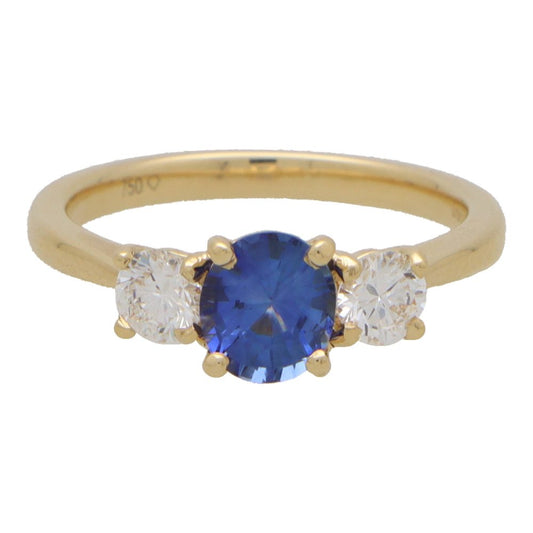 Diamond and sapphire three stone ring in yellow gold.
