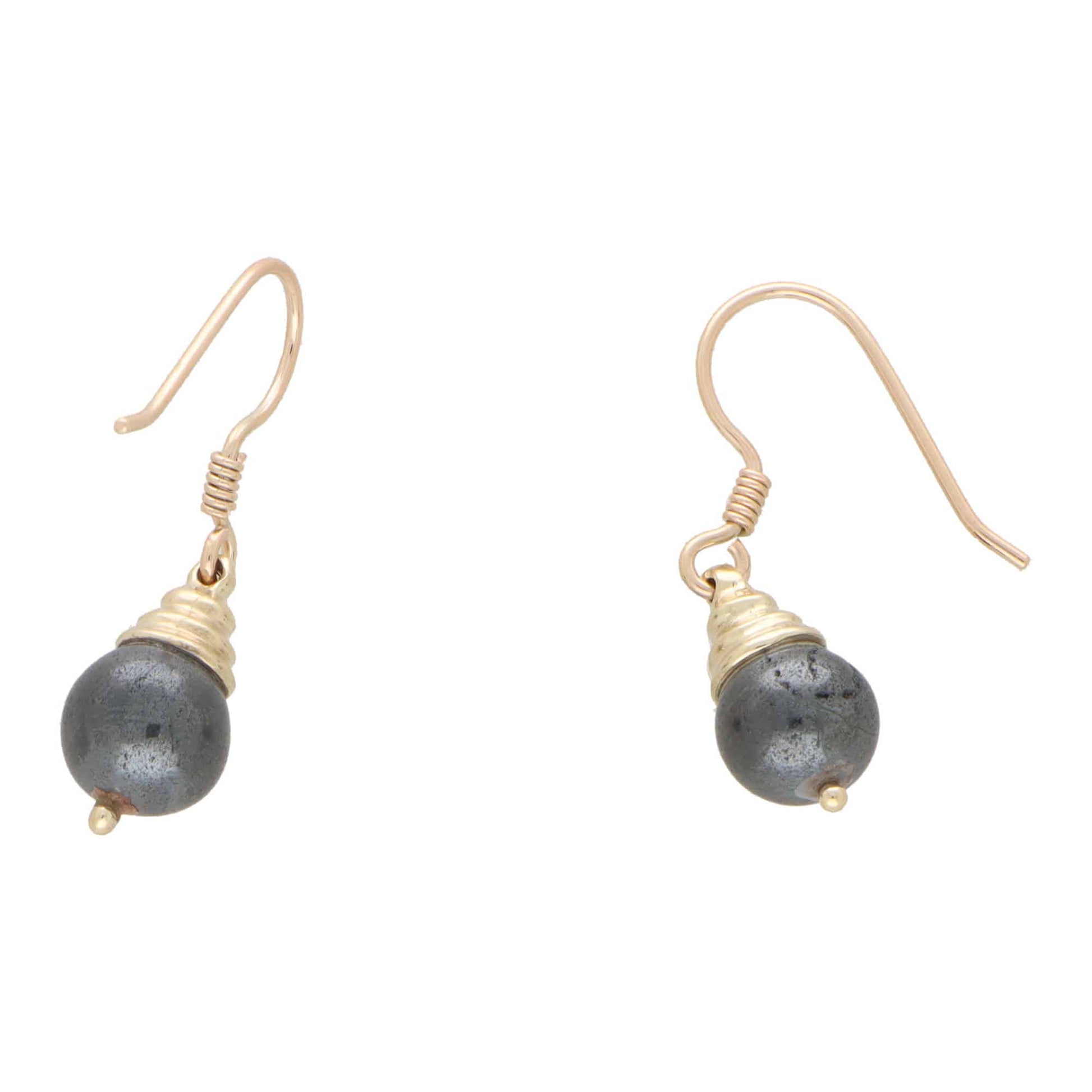 A pair of hematite drop earrings in yellow gold on a white background