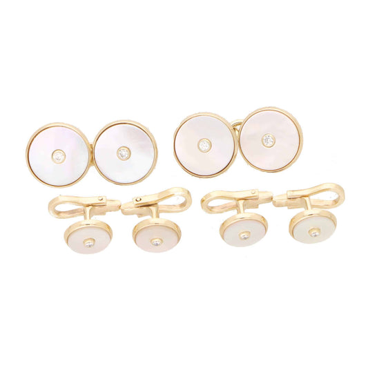 A pair of mother-of-pearl and diamond cufflinks in yellow gold with matching shirt studs, on a white background