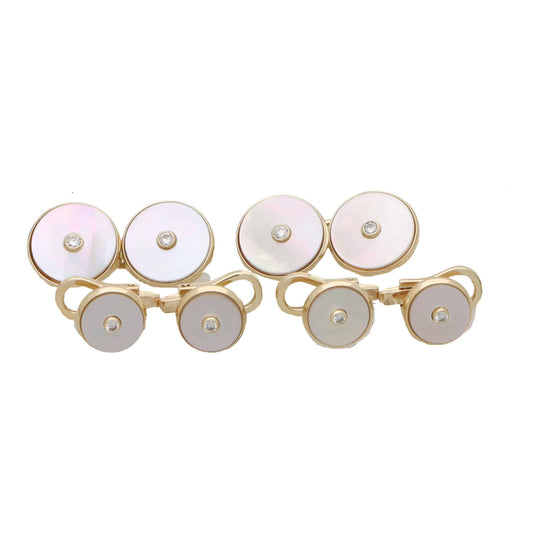 A pair of circular mother of pearl and diamond cufflinks in yellow gold with matching dress studs