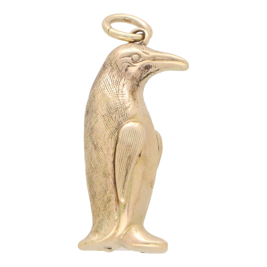 A yellow gold penguin charm, on a white background