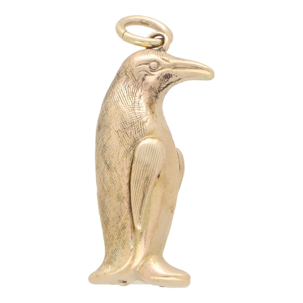 A yellow gold penguin charm, on a white background