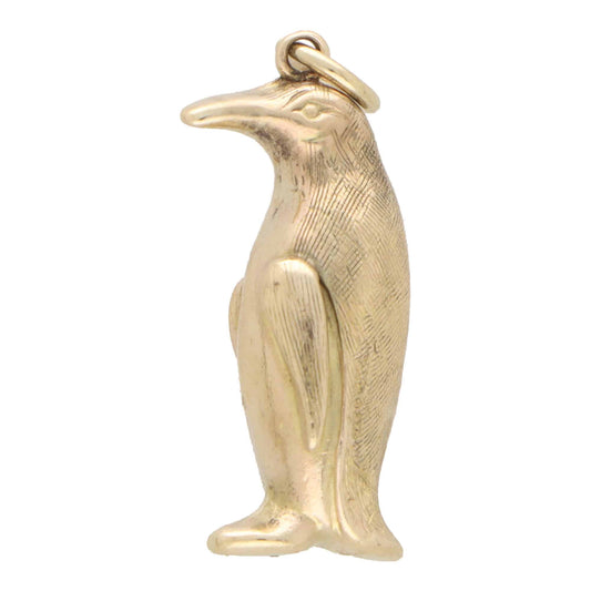 A yellow gold penguin charm, on a white background