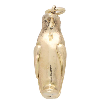 A yellow gold penguin charm, on a white background