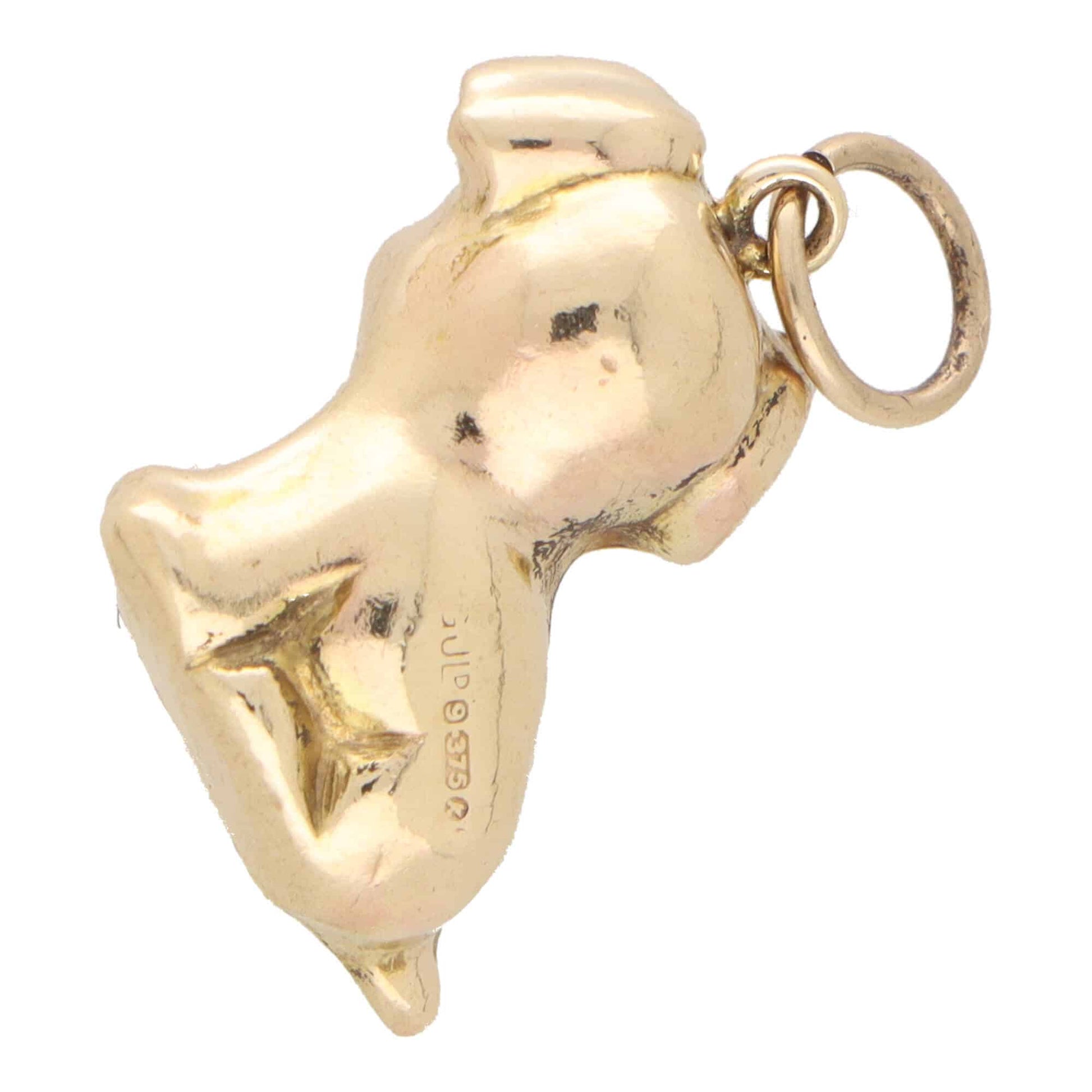 A yellow gold puppy dog charm, on a white background
