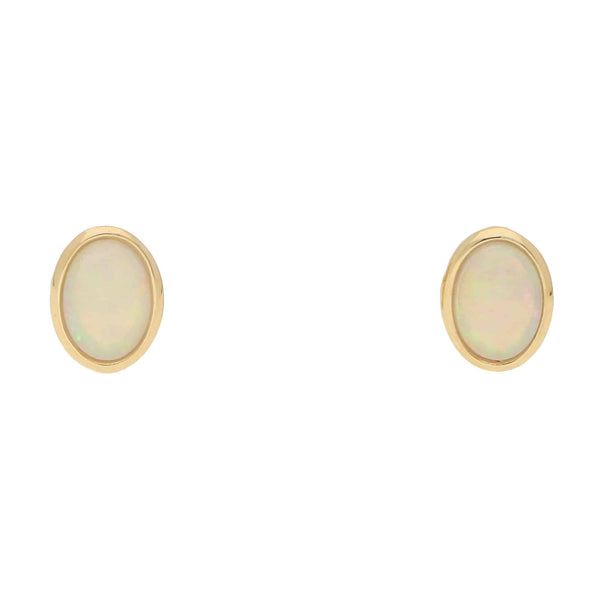 A pair of oval opal earrings in yellow gold, on a white background