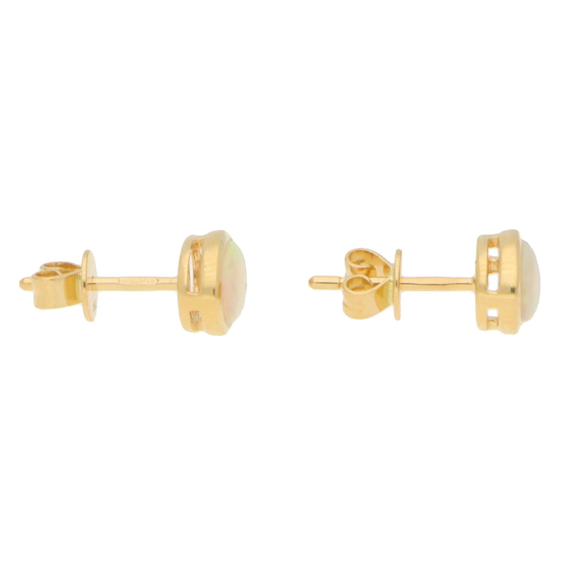 A pair of oval opal earrings in yellow gold, on a white background