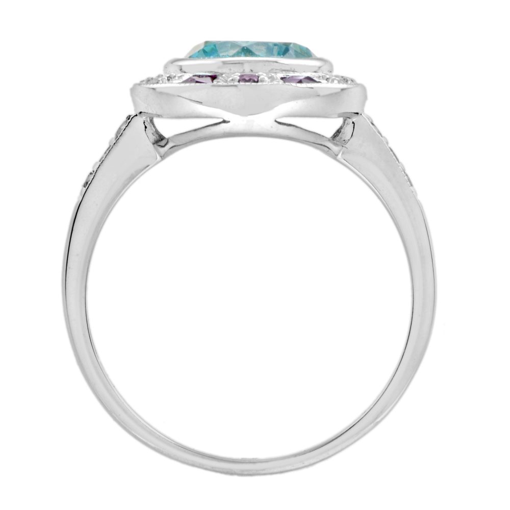 2.75ct Blue Zircon Ring with Ruby and Diamond Halo Cluster, central round-cut blue zircon is surrounded by rubies with a deep pink hue and diamonds with diamond-set shoulders in 14ct white gold