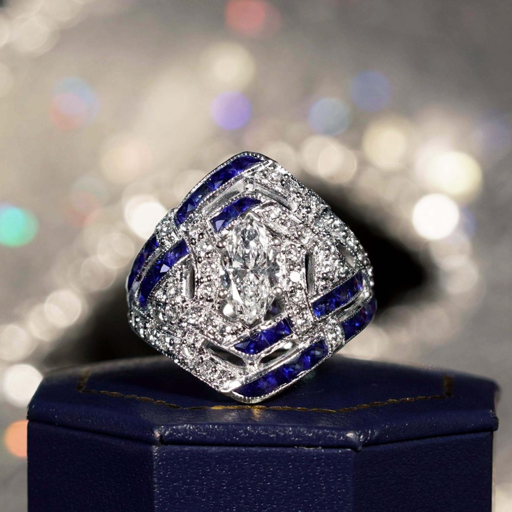 GIA 1ct Marquise Diamond and Sapphire Cluster Dress Ring, D Colour Internally Flawless, GIA Certified D IF 1ct marquise-cut diamond centrally set to tapered navette surround studded with sparkling diamonds accented with lines of French cut blue sapphires in 18ct white gold with a GIA certificate