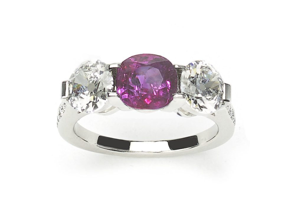 Burma ruby and diamond three stone ring.The central round Burma ruby weighing approximately 1.94ct, round brilliant cut diamonds platinum 2 3 carats