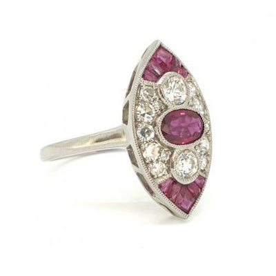 Ruby and Diamond Three Stone Cluster Navette Ring; oval red ruby flanked top and bottom by a brilliant-cut diamond surrounded by diamonds and calibre rubies