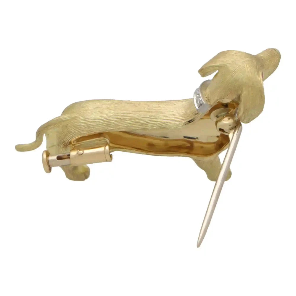 Diamond and ruby Dachshund dog brooch in gold.