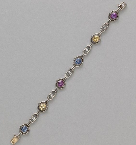 Art Deco Multi Colour Sapphire and Diamond Bracelet; oval links set with a natural facetted oval sapphire; two yellow, two pink and two blue, accented with rose cut diamonds and white sapphires, in silver and gold, Circa 1920