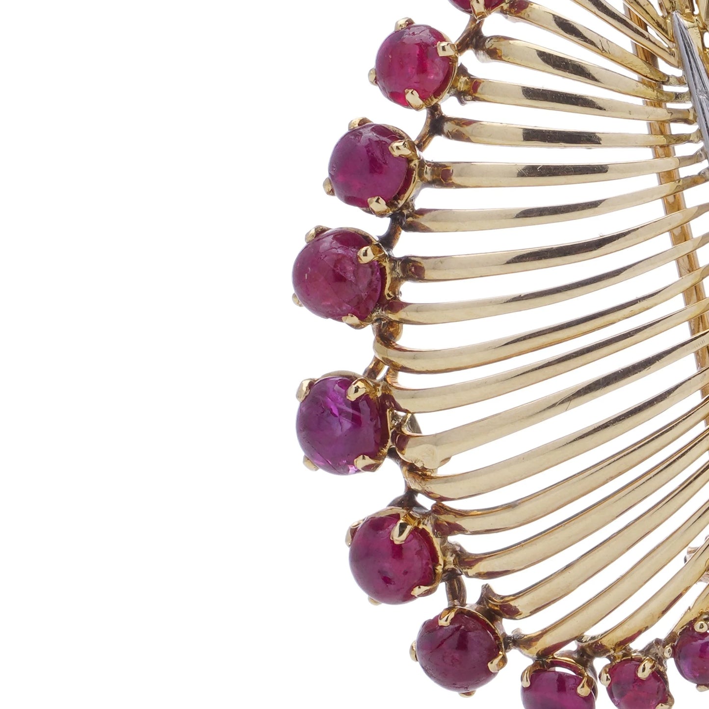 A gold and platinum leaf shaped brooch with baguette cut diamonds and cabochon cut rubies, on a white background