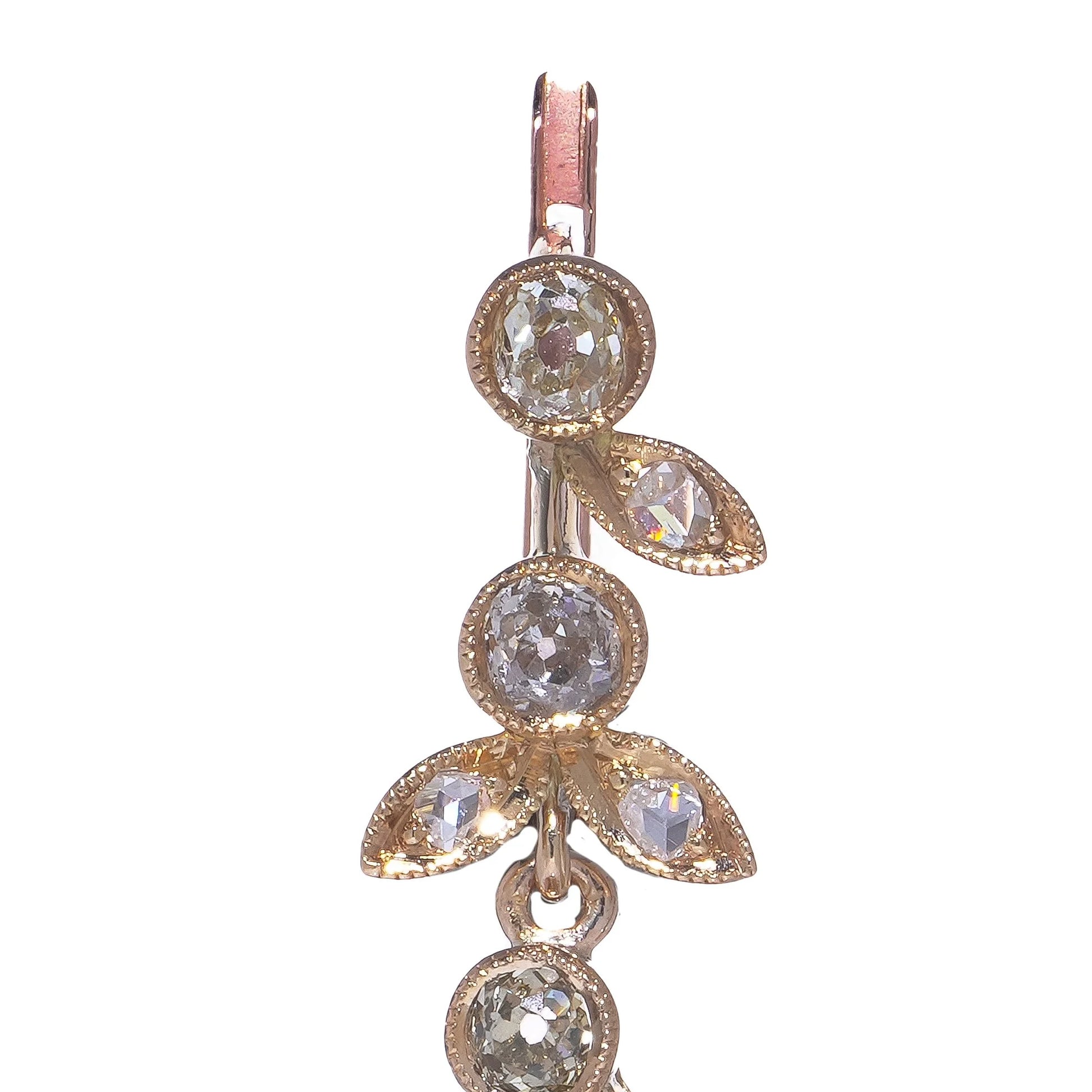 A pearl and old cut diamond drop earring with leaf motifs in yellow gold, on a white background