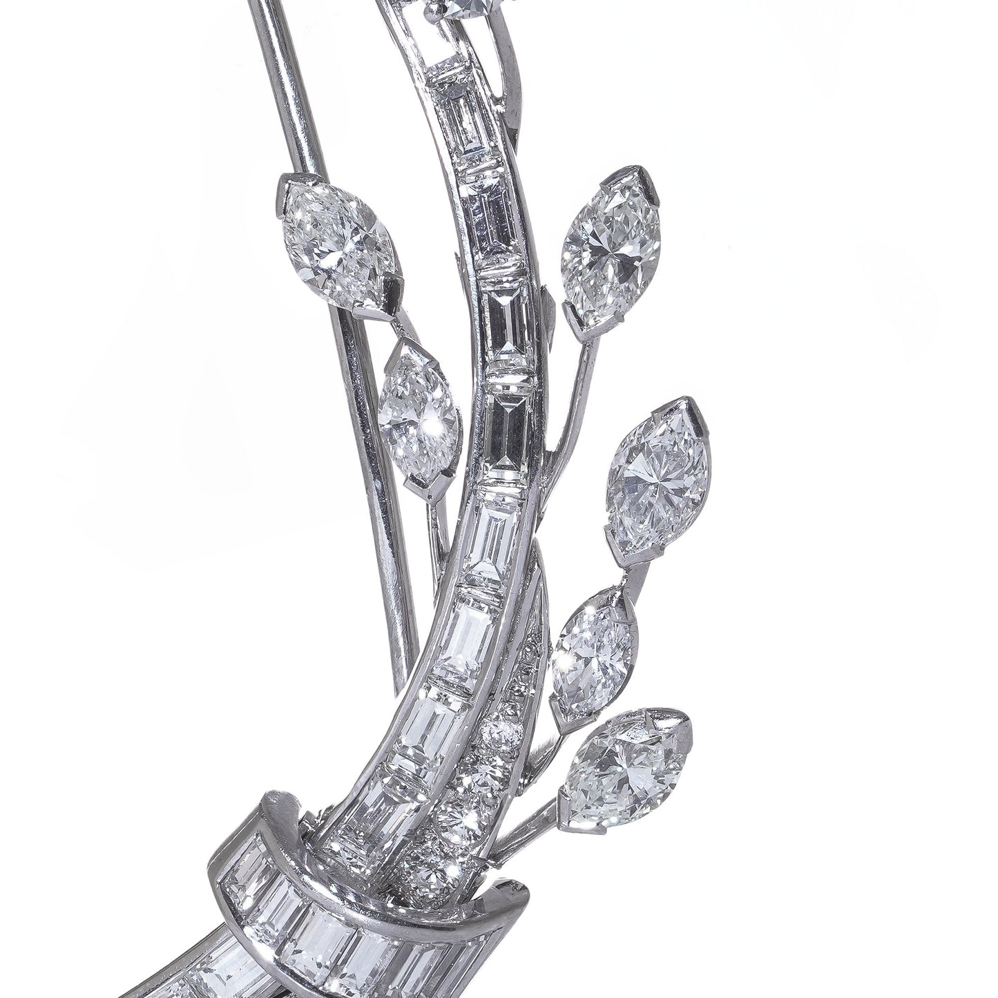 A leaf design brooch set with baguette, marquise and brilliant cut diamonds in white metal, on a white background