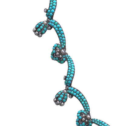 An antique turquoise bead and pearl fancy necklace, on a white background