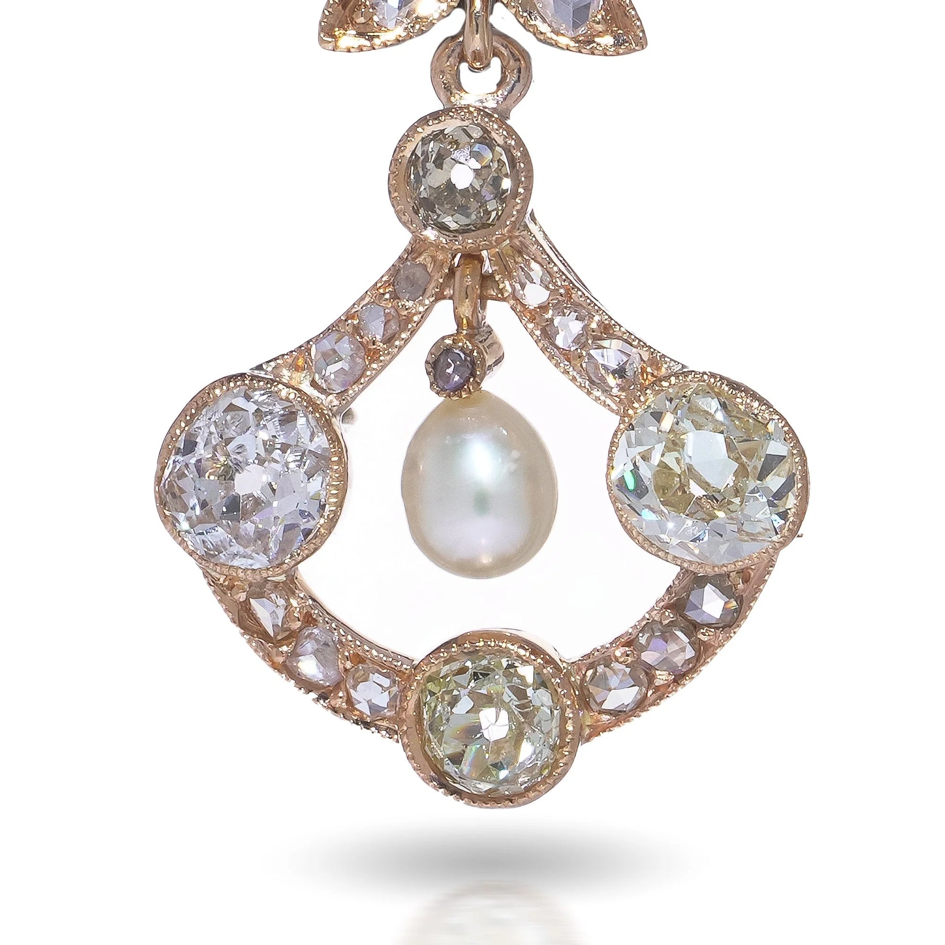 A pearl and old cut diamond drop earring with leaf motifs in yellow gold, on a white background