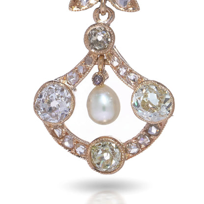 A pearl and old cut diamond drop earring with leaf motifs in yellow gold, on a white background