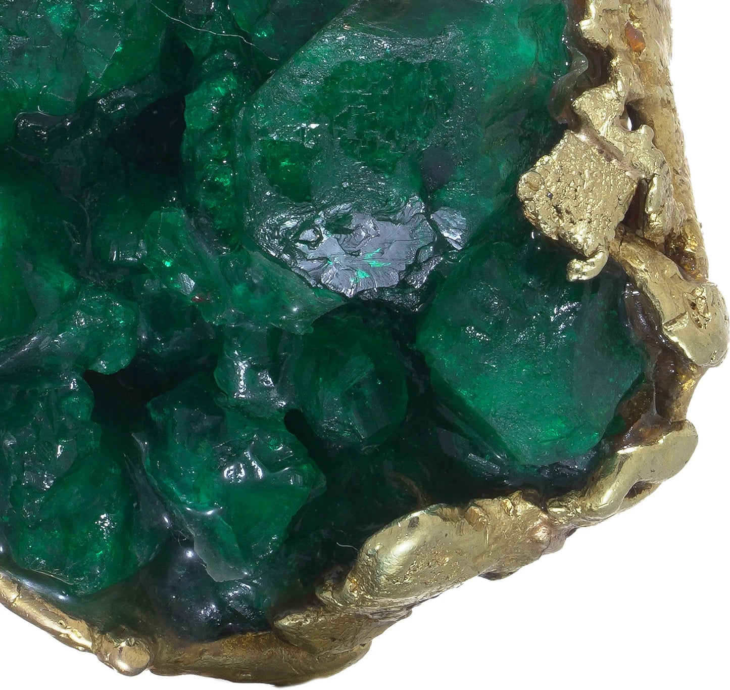 A yellow gold free-form pendant with a rough cut emerald, on a white background