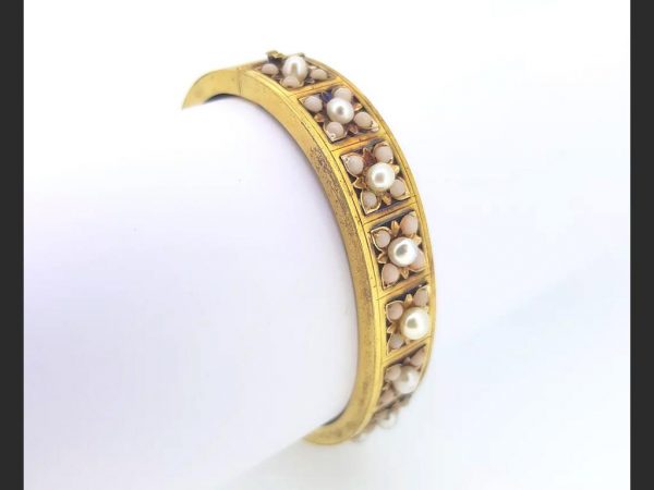 Victorian Natural Pearl and Angel Skin Coral Bangle; An antique 15ct yellow gold bangle, set with natural pearls and angel skin coral. A statement piece