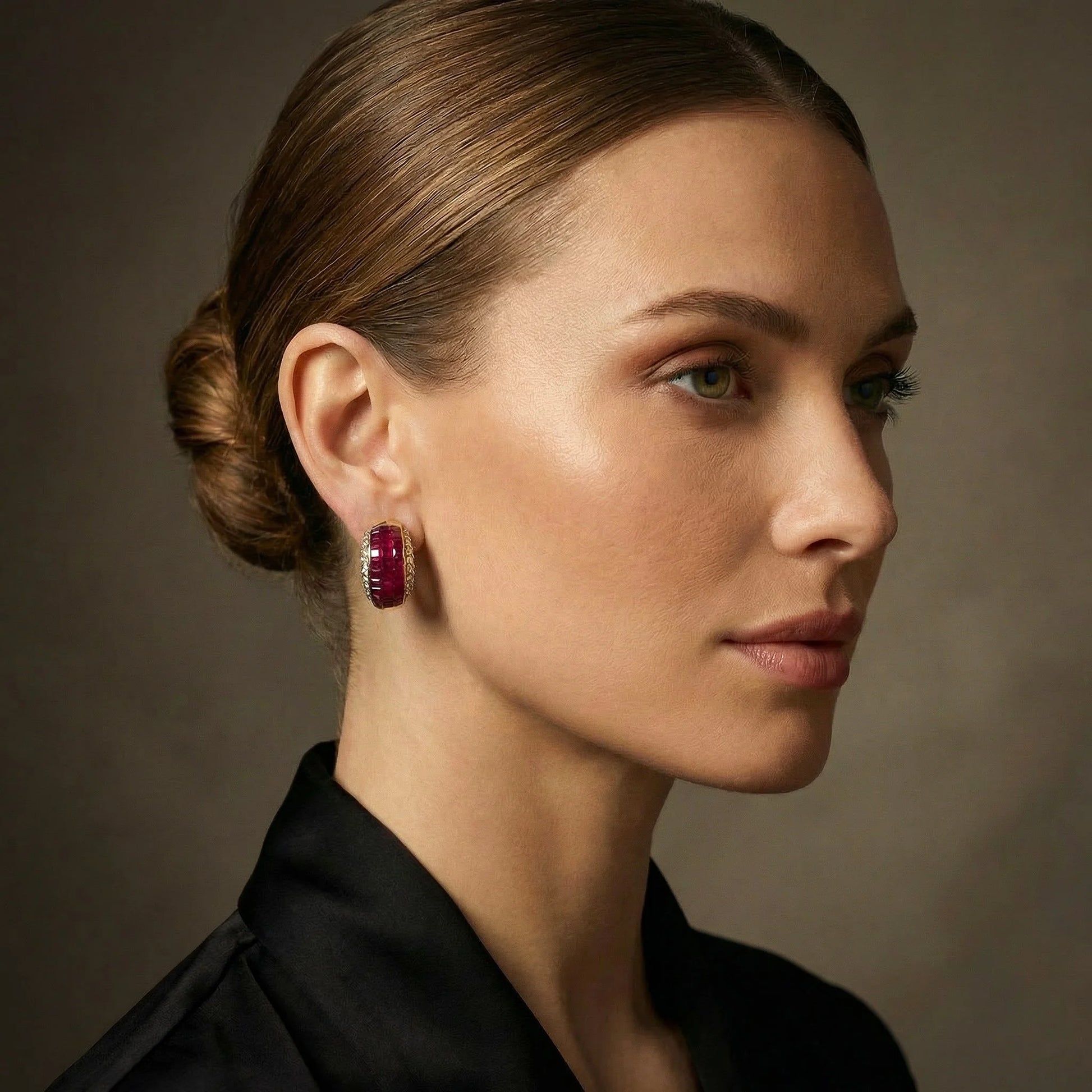 A yellow gold square cut ruby and round diamond earring, modelled on an ear
