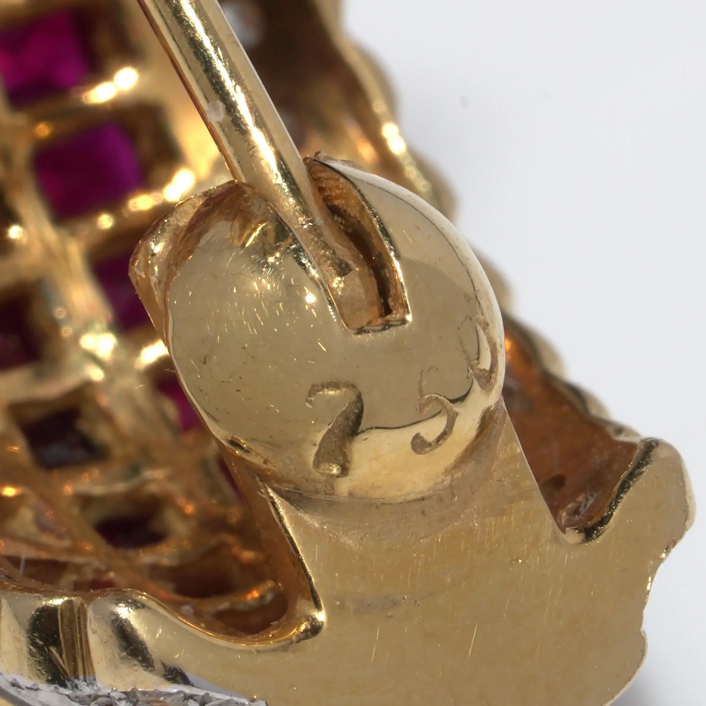 Close-up of a 750 stamp on a yellow gold earring