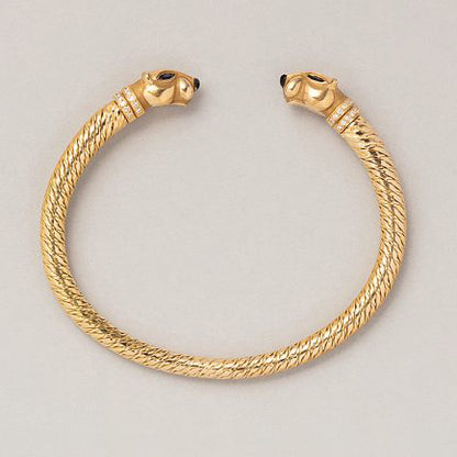 Vintage Cartier Panthere Gold Bangle Bracelet, 18ct yellow gold bangle bracelet with a panther head at both ends with sapphire eyes, onyx noses and diamond-set collars