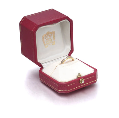 A diamond band in yellow, rose and white gold, in a Cartier ring box
