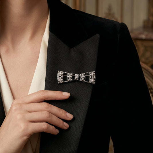 A floral design diamond and platinum bow brooch with a black ribbon, modelled on a black jacket