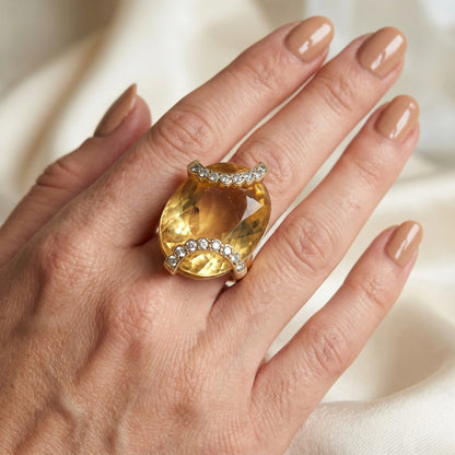 An oval citrine and diamond cocktail ring in yellow gold, modelled on a hand
