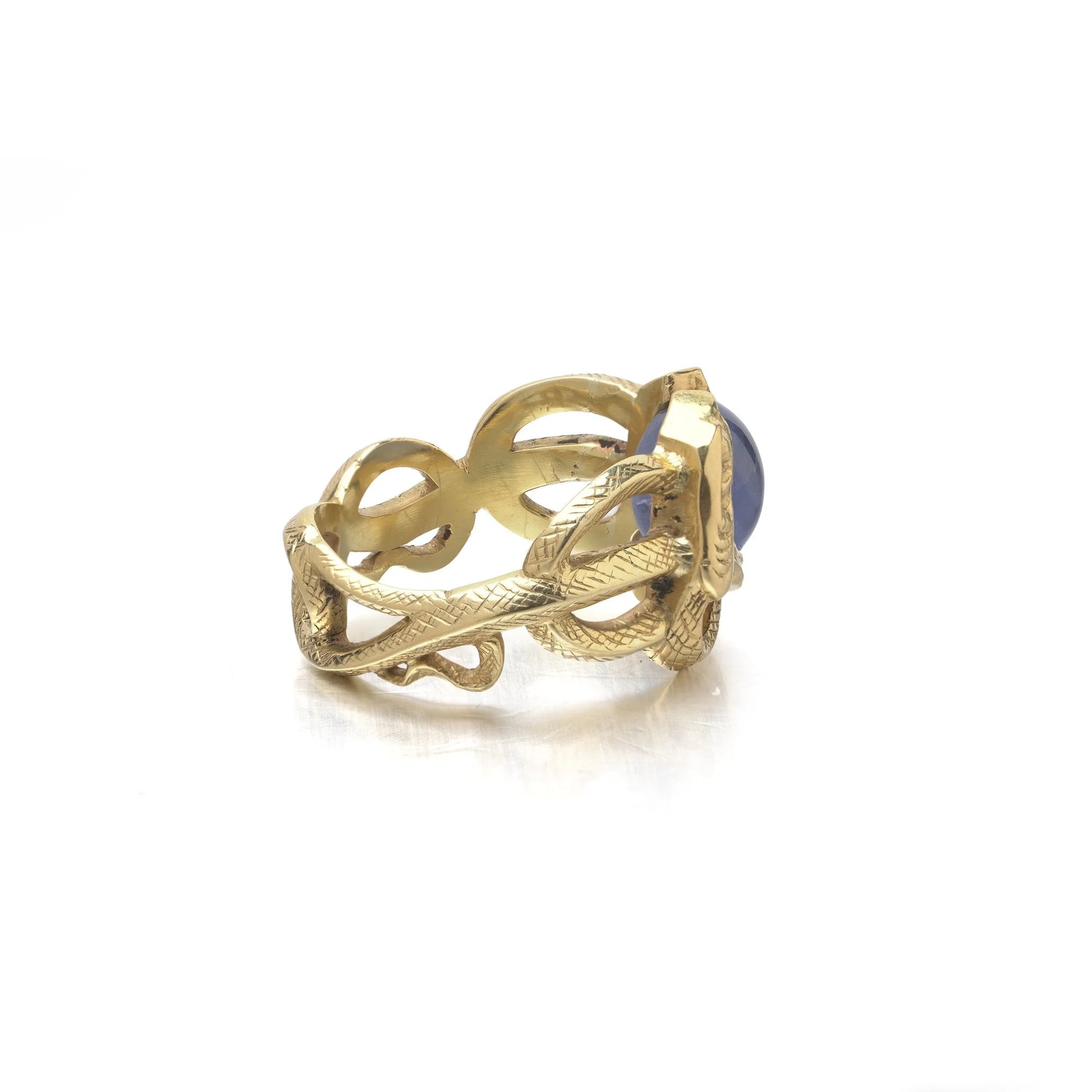 A yellow gold double snake ring holding a cabochon star sapphire in their mouths