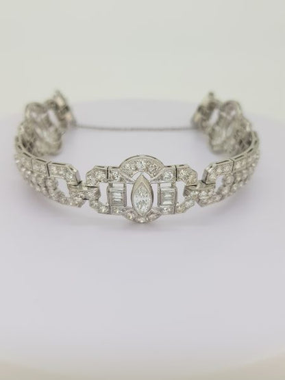 Vintage Geometric Diamond Bracelet in Platinum; central marquise cut diamond set within an open panel border decorated with baguette-cut and round brilliant-cut diamonds, Circa 1960s.