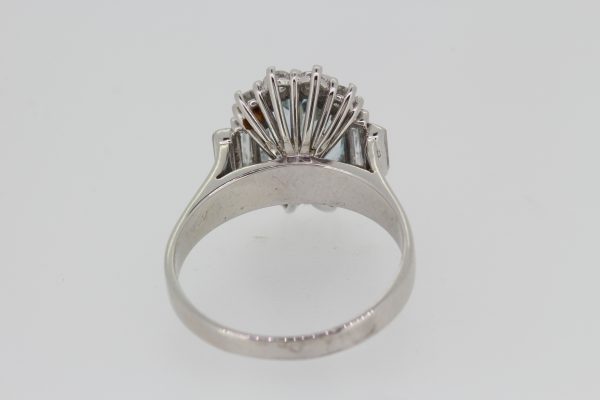 Aquamarine and Diamond Oval Cluster Ring; central 2.00ct oval faceted aquamarine bordered by brilliant cut diamonds, graduated baguette-cut diamond set shoulders, in 18ct white gold