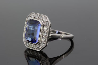 Tanzanite and Diamond Cluster Dress Tablet Ring; central bezel-set 4.50ct emerald-cut tanzanite surrounded by 0.80cts pave-set diamonds, in 18ct white gold