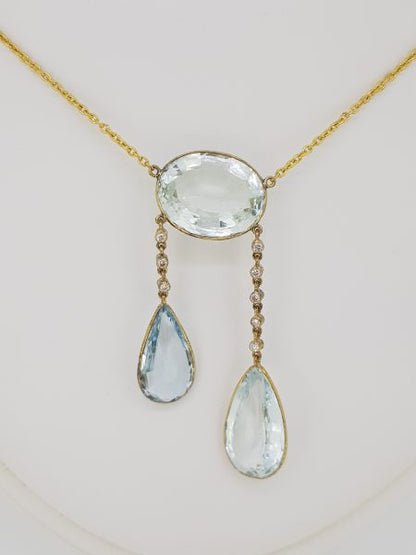 Aquamarine and Diamond Negligee Pendant, 25 carat total, featuring an oval aquamarine suspending two pear-cut aquamarines via diamond-set links, in 18ct yellow gold