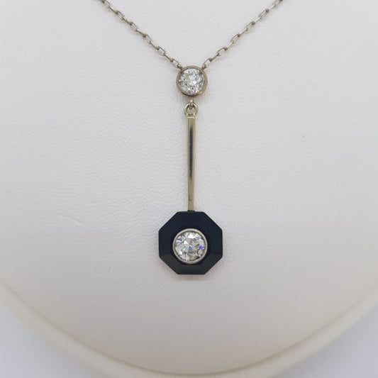 Onyx and Diamond Drop Pendant; hexagonal-shaped onyx with a diamond set centre suspended from another diamond via a gold bar, 1.25 carat total