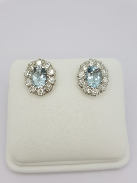 Aquamarine and Diamond Oval Cluster Stud Earrings; featuring 2.50cts oval facetted aquamarines within 1.90ct diamond surrounds, in 18ct white gold