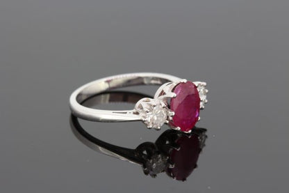 Ruby and Diamond Three Stone Ring; 1.90 carat oval faceted ruby flanked by 0.50cts round brilliant-cut diamonds, claw set in 18ct white gold