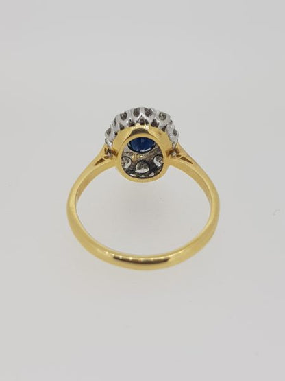 Vintage Sapphire and Diamond Cluster Ring; central oval sapphire within a diamond surround, in 18ct gold, Circa 1970s