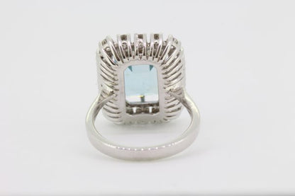 Emerald Cut Aquamarine and Diamond Cluster Ring; central 4.64ct emerald-cut aquamarine within a 0.95ct diamond surround, in 18ct white gold