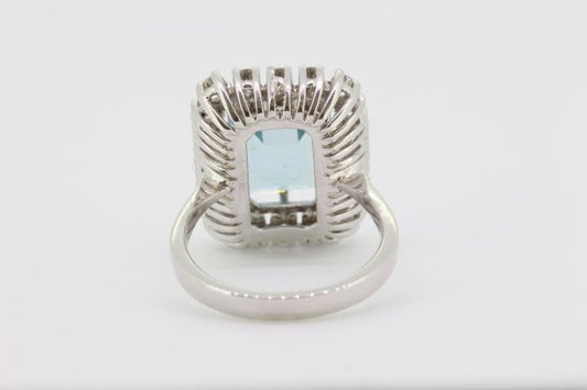 Emerald Cut Aquamarine and Diamond Cluster Ring; central 4.64ct emerald-cut aquamarine within a 0.95ct diamond surround, in 18ct white gold