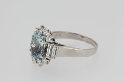 Aquamarine and Diamond Oval Cluster Ring; central 2.00ct oval faceted aquamarine bordered by brilliant cut diamonds, graduated baguette-cut diamond set shoulders, in 18ct white gold