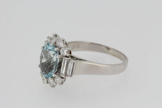 Aquamarine and Diamond Oval Cluster Ring; central 2.00ct oval faceted aquamarine bordered by brilliant cut diamonds, graduated baguette-cut diamond set shoulders, in 18ct white gold