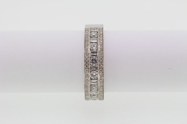 Channel Set Diamond Ring; channel set brilliant and baguette-cut diamonds flanked by rows of pave-set diamonds, 1.00 carat total, in 18ct white gold