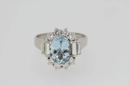Aquamarine and Diamond Oval Cluster Ring; central 2.00ct oval faceted aquamarine bordered by brilliant cut diamonds, graduated baguette-cut diamond set shoulders, in 18ct white gold