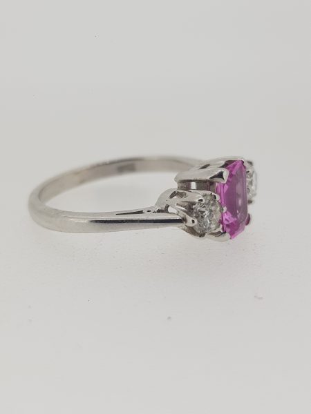 Emerald Cut Pink Sapphire and Diamond Three Stone Ring; central 1.01ct emerald-cut pink sapphire flanked by 0.40cts brilliant-cut diamonds, in 18ct white gold