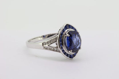 Sapphire and Diamond Navette Shaped Cluster Ring; central 1.40ct oval sapphire within navette-shaped border of French-cut sapphires, with diamond set split shoulders, in 18ct white gold